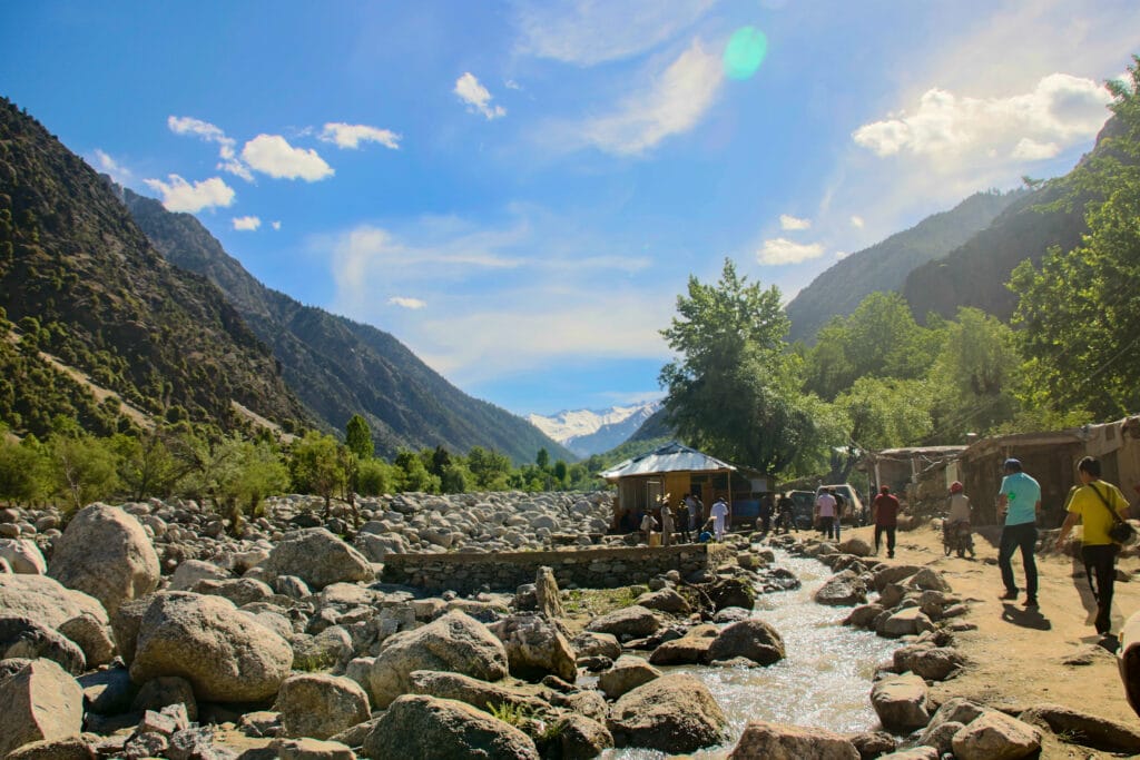 Valle de Kalash en el distrito de Chitral, Pakistán, rodeado de montañas y un riachuelo de piedras